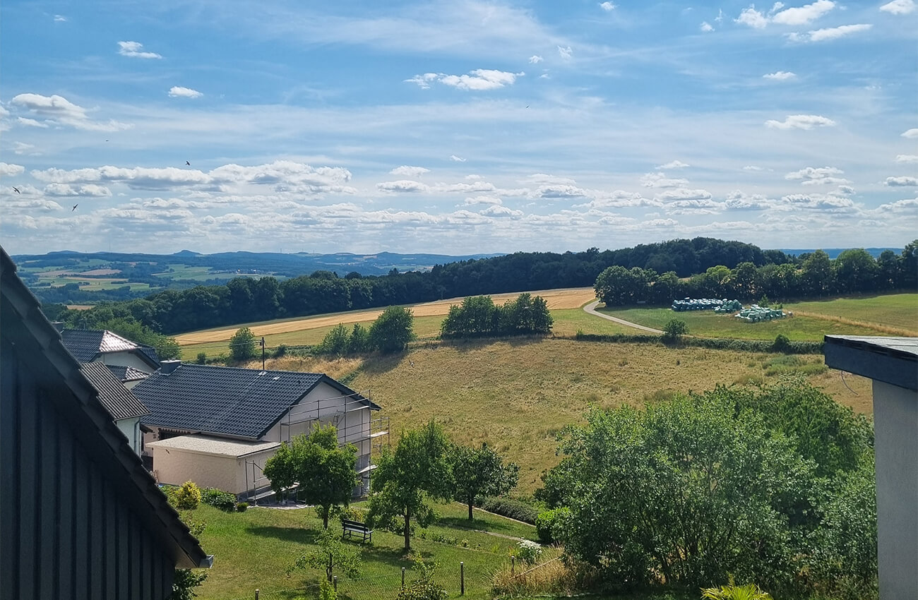 Panoramablick über die Eifel mit Feldern, Hügeln und weitem Horizont bei Rodder